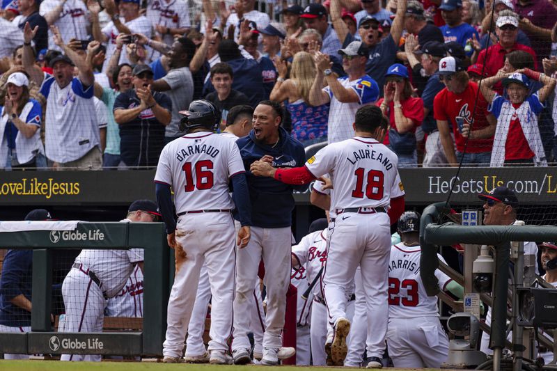 Atlanta Braves' Travis d'Arnaud, left, Orlando Arcia, center, and Ramón Laureano, right, celebrate after scoring in the eighth inning of a baseball game against the New York Mets, Monday, Sept. 30, 2024, in Atlanta. (AP Photo/Jason Allen)