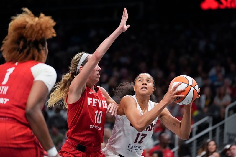 Atlanta Dream's Nia Coffey (12) dribbles the ball against Indiana Fever's Lexie Hull (10) in the second half of an WNBA basketball game, Monday, Aug. 26, 2024, in Atlanta. (AP Photo/Brynn Anderson)