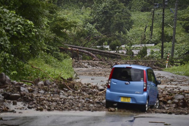 A car is blocked by rocks covering a road, after heavy rain in Wajima, Ishikawa prefecture, Saturday, Sept. 21, 2024. (Kyodo News via AP)