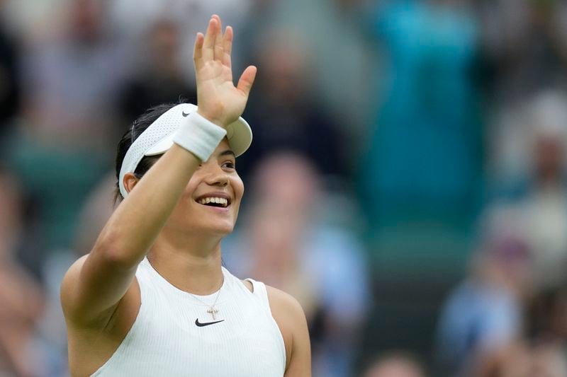 Britain's Emma Raducanu waves after defeating Elise Mertens of Belgium in their match on day three at the Wimbledon tennis championships in London, Wednesday, July 3, 2024. (AP Photo/Mosa'ab Elshamy)