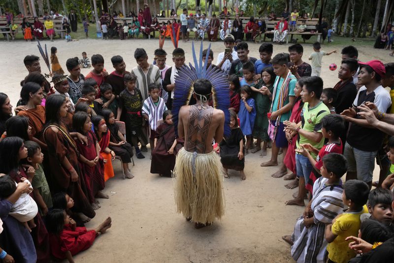 Charles Apolima, center, judges the work of participants in a face painting contest during the annual celebration recognizing the Ashaninka territory in the Apiwtxa village, Acre state, Brazil, Sunday, June 23, 2024. (AP Photo/Jorge Saenz)