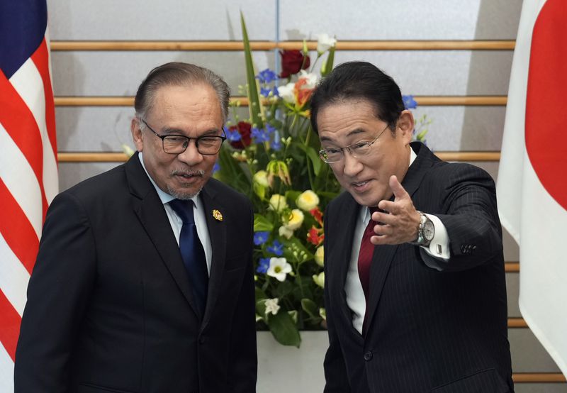 Japanese Prime Minister Fumio Kishida, right, invites Malaysian Prime Minister Anwar Ibrahim to take a seat at the start of their meeting at the prime minister's office in Tokyo, Thursday, May 23, 2024. (Franck Robichon/Pool Photo via AP)
