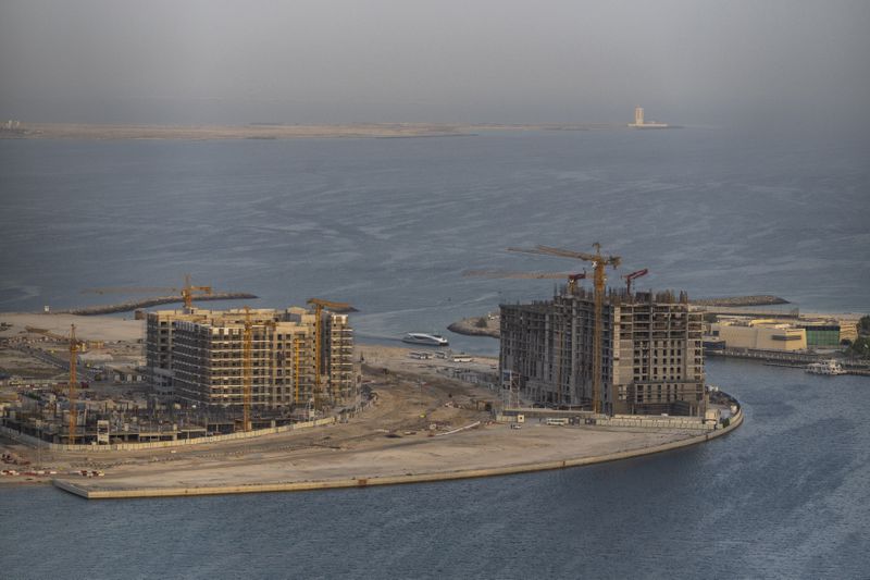 A ferry sails by a construction site in Al Khan, near Dubai, United Arab Emirates, Tuesday, Aug. 13, 2024. (AP Photo/Altaf Qadri)