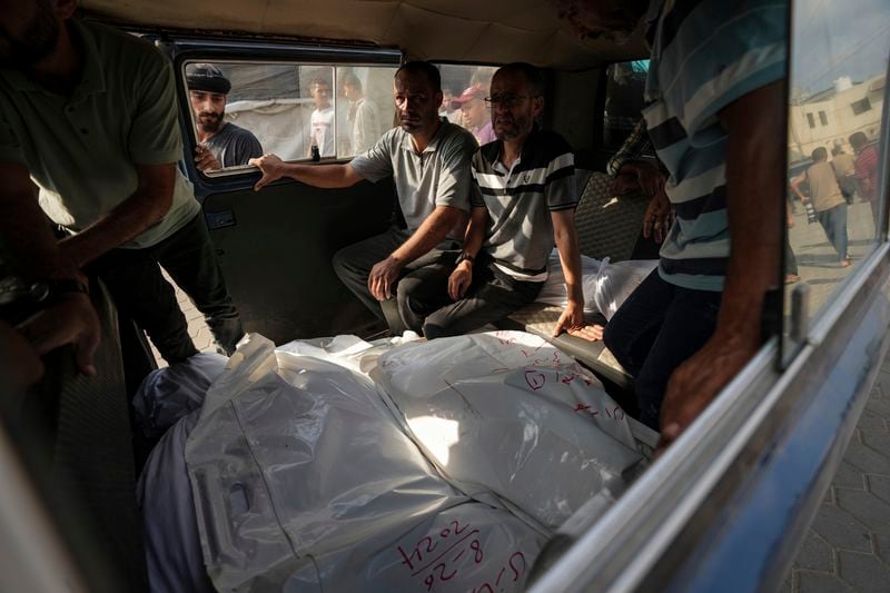 Palestinians mourn relatives killed in the Israeli bombardment of the Gaza Strip, at a hospital in Deir al-Balah, Tuesday, Aug. 27, 2024. (AP Photo/Abdel Kareem Hana)