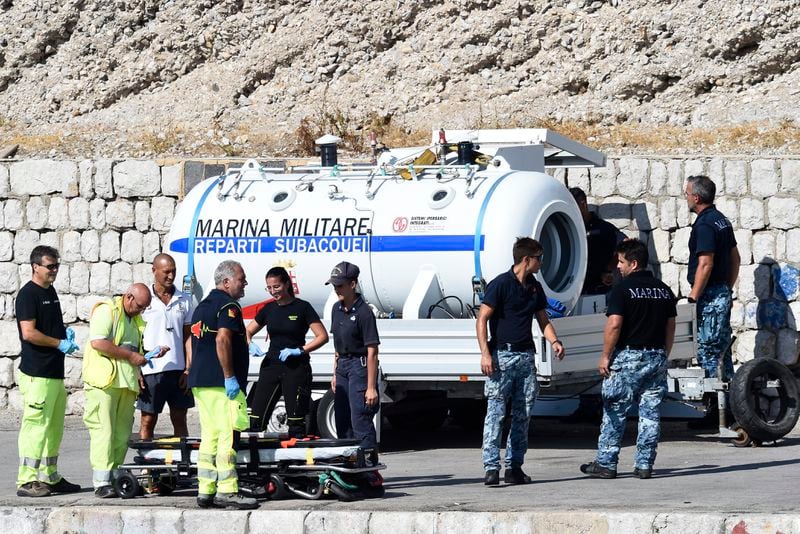 Italian Navy scuba divers set a hyperbaric chamber as they work at the scene of the search for a missing boat, in Porticello, southern Italy, Thursday, Aug. 22, 2024. Rescue teams and divers returned to the site of a storm-sunken super yacht to search for one person, who are believed to be still trapped in the hull 50 meters (164-feet) underwater. (AP Photo/Salvatore Cavalli)