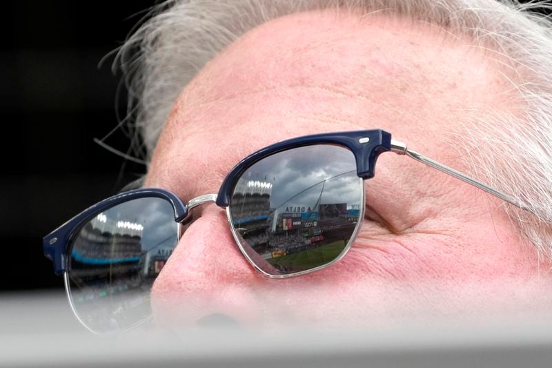 Yankee Stadium is reflected in a fan's glasses during the eighth inning of a baseball game between the Atlanta Braves and the New York Yankees, Sunday, June 23, 2024, in New York. (AP Photo/Pamela Smith)