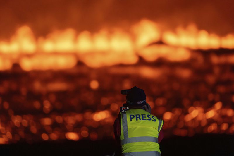 Photographers and journalists on location filming and reporting on the new fissure north of Grindavik, Iceland, Thursday, Aug. 22, 2024, (AP Photo/Marco di Marco)