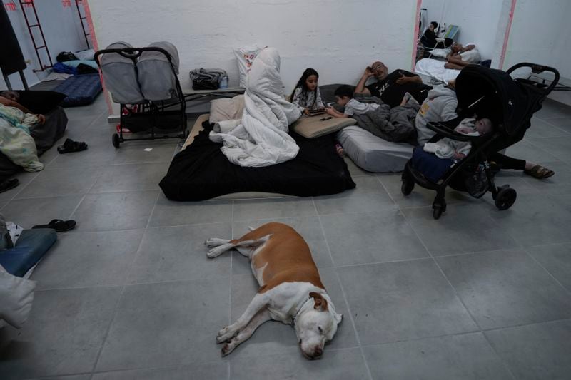 Israelis stay in a residential building bomb shelter to stay safe from rockets fired from Lebanon, in Kiryat Haim, northern Israel, on Tuesday, Sept. 24, 2024. (AP Photo/Baz Ratner)