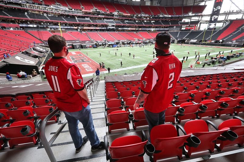 102520 Atlanta: Falcons fans Adam Waterman (left) and Michael Levalleh watch the team prepare to play the Detroit Lions Sunday, Oct. 25, 2020, at Mercedes-Benz Stadium in Atlanta. (Curtis Compton / Curtis.Compton@ajc.com)