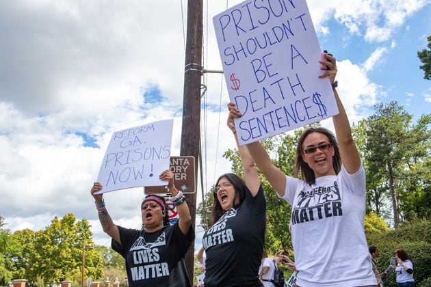 Incarcerated Lives Matter protesters, including Jenny Arellano, from left, Aubri Escalera and Dr. Christy Perez, right, call for reform of the Georgia prison system with a gathering across the street from the Governor's Mansion on Tuesday. That day, the U.S. Department of Justice released a damning report on violent conditions within the state's prison system. (Jenni Girtman for The Atlanta Journal-Constitution)