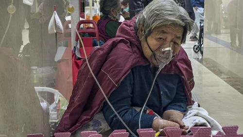 FILE - An elderly patient receives an intravenous drip while using a ventilator in the hallway of the emergency ward in Beijing, Thursday, Jan. 5, 2023. (AP Photo/Andy Wong, File)