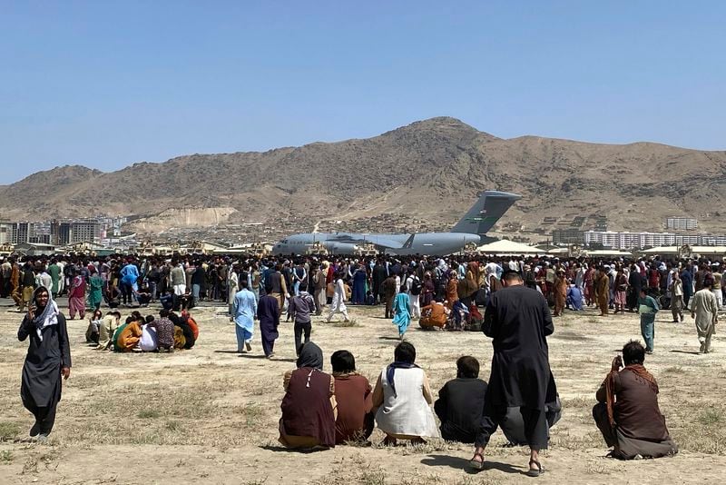 FILE - Hundreds of people gather near a U.S. Air Force C-17 transport plane at the perimeter of the international airport in Kabul, Afghanistan, on Aug. 16, 2021. (AP Photo/Shekib Rahmani, File)