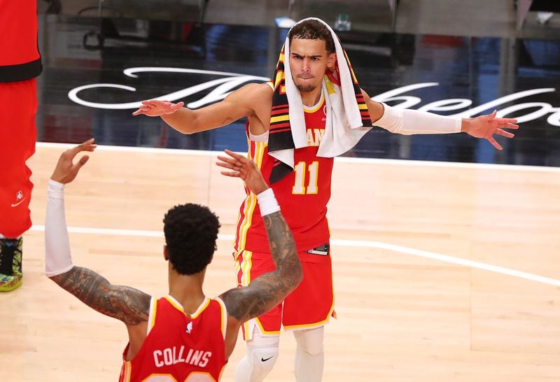 Hawks John Collins and Trae Young celebrate at the end of a 120-116 victory over the Washington Wizards to clinch a playoff spot Wednesday, May 12, 2021, in Atlanta. (Curtis Compton / Curtis.Compton@ajc.com)