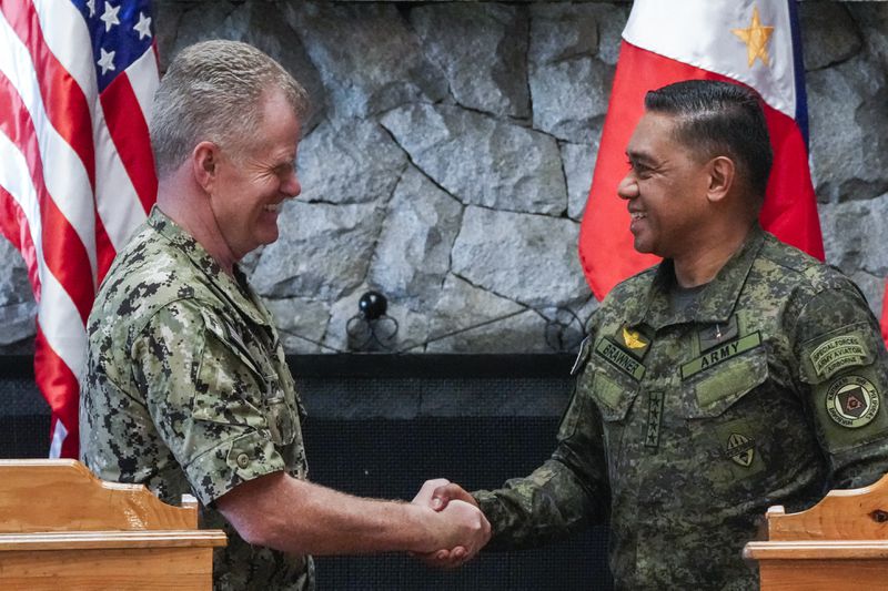 U.S. Indo-Pacific Command Commander Admiral Samuel Paparo, left, and Philippines military chief Gen. Romeo Brawner Jr.,shake hands after a press conference on the Mutual Defense Board-Security Engagement Board held at the Philippine Military Academy in Baguio, northern Philippines on Thursday, Aug. 29, 2024. (AP Photo/Aaron Favila)