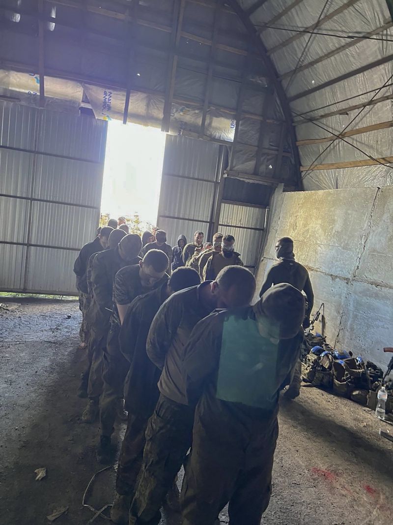 In this photo provided by the Ukrainian Security Service Press Office, over 100 Russian prisoners of war captured by a Security Service special unit during one military action are seen in a shelter in Kursk region, Russia, Wednesday, Aug. 14, 2024. (Ukrainian Security Service Press Office via AP)