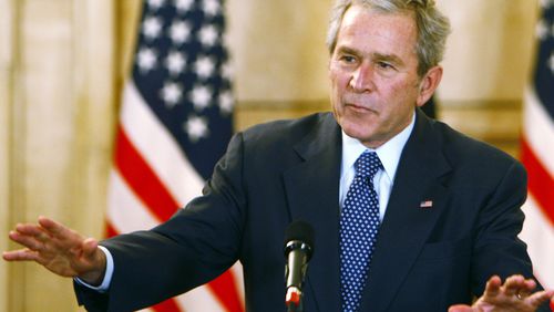 U.S. President George W. Bush reacts to calm the situation after a shoe was thrown by a reporter during a joint press conference with Iraqi Prime Minister Nuri al-Maliki (not pictured) on December 14, 2008 in Baghdad, Iraq. (Photo by Thaier al-Sudani-Pool/Getty Images)