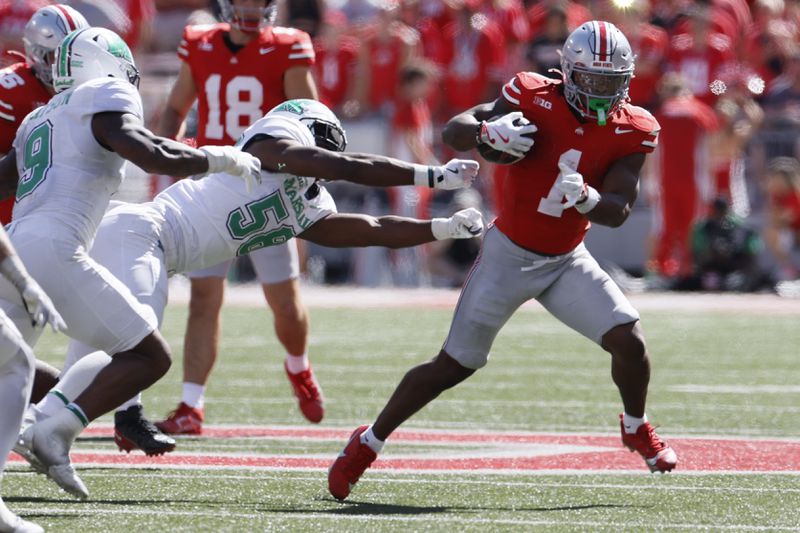 Ohio State running back Quinshon Judkins, right, tries to get away from Marshall defensive lineman Braydin Ward during the second half of an NCAA college football game, Saturday, Sept. 21, 2024, in Columbus, Ohio. (AP Photo/Jay LaPrete)