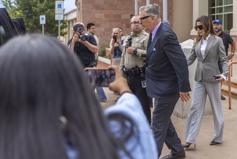 Actor Alec Baldwin, center right, and his wife Hilaria leave court the judge threw out the involuntary manslaughter case for the 2021 fatal shooting of cinematographer Halyna Hutchins during filming of the Western movie "Rust," Friday, July 12, 2024, in Santa Fe, N.M. (Luis Sánchez Saturno/Santa Fe New Mexican via AP)