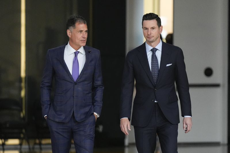 JJ Redick, right, walks to the podium with Los Angeles Lakers general manager Rob Pelinka, left, before being introduced as the new head coach of the Lakers NBA basketball team Monday, June 24, 2024, in El Segundo, Calif. (AP Photo/Damian Dovarganes)