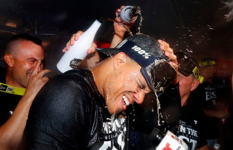 New York Yankees outfielder Juan Soto, center, celebrates with teammates after they clinched the American League East title in a baseball game against the Baltimore Orioles, Thursday, Sept. 26, 2024, in New York. (AP Photo/Noah K. Murray)