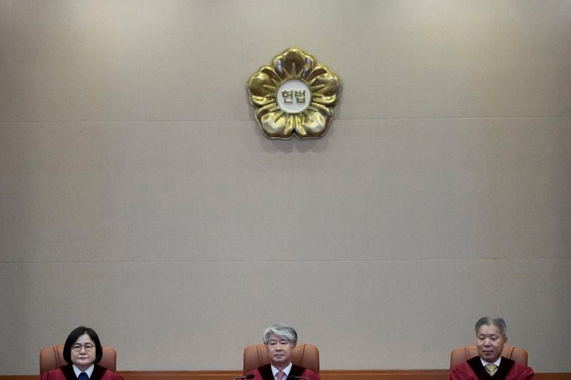 South Korea's Constitutional Court Chief Justice Lee Jong-seok, center, and other judges sit upon their arrival at the Constitutional Court in Seoul, South Korea, Thursday, Aug. 29, 2024. (AP Photo/Lee Jin-man)