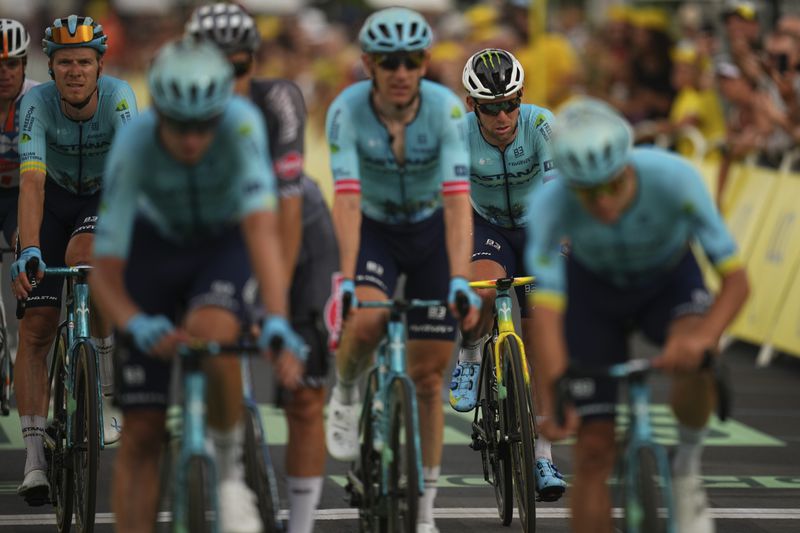 Britain's Mark Cavendish who was distanced by the pack, second right, is brought to the finish line by his Astana Qazaqstan Team in the first stage of the Tour de France cycling race over 206 kilometers (128 miles) with start in Florence and finish in Rimini, Italy, Saturday, June 29, 2024. (AP Photo/Daniel Cole)