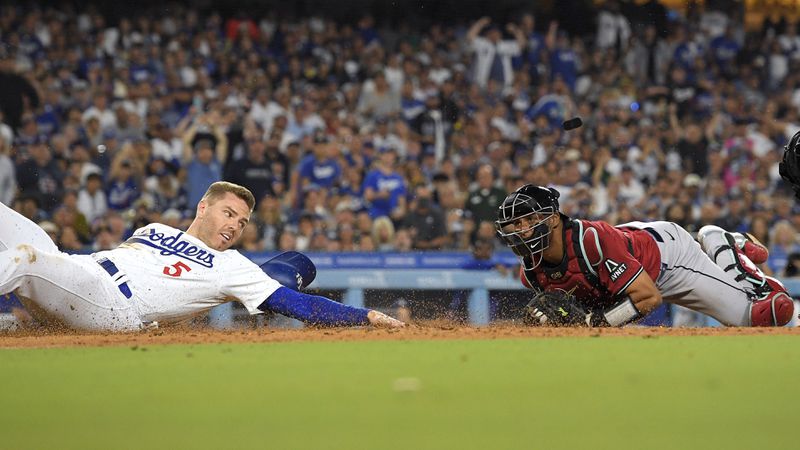 Los Angeles Dodgers' Freddie Freeman, left, looks back after being tagged out by Arizona Diamondbacks catcher Gabriel Moreno as he tried to score from third on the line out by Miguel Rojas during the third inning of a baseball game Wednesday, July 3, 2024, in Los Angeles. (AP Photo/Mark J. Terrill)