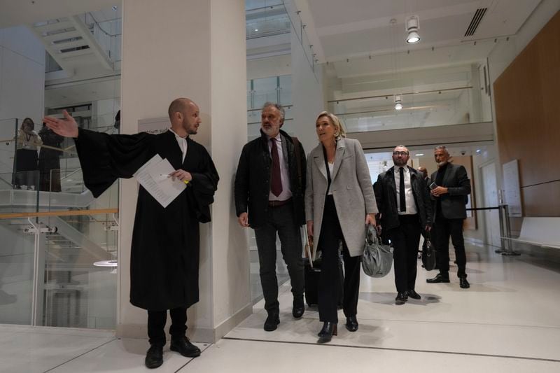 French far-right leader Marine Le Pen, center, arrives with her legal team at the court house in Paris, Monday, Sept. 30, 2024. (AP Photo/Thibault Camus)