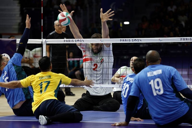 Iran's Morteza Mehrzadselakjani blocks the ball during the preliminary sitting volleybal match against Brazil during the Paralympic Games in Paris, Sunday, Sept. 1, 2024. Iran won the game in straight sets. (AP Photo/Avni Trivedi)