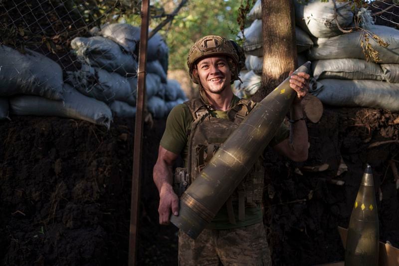 Ukrainian serviceman Oleh of 148th separate artillery brigade of the Air Assault Forces carries 155mm artillery shell during firing towards Russian positions at the frontline in Donetsk region, Ukraine, Wednesday, August 21, 2024. (AP Photo/Evgeniy Maloletka)