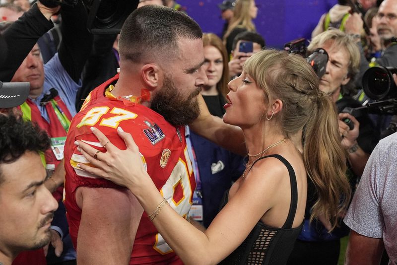 FILE = Kansas City Chiefs tight end Travis Kelce (87) speaks to Taylor Swift after the team's NFL Super Bowl 58 football game against the San Francisco 49ers, Feb. 11, 2024, in Las Vegas. A 170-year-old rivalry is flaring up as Kansas lawmakers try to snatch the Super Bowl champion Kansas City Chiefs away from Missouri. The team has international cache after three Super Bowl titles in five years and because of Kelce’s romance with pop icon Swift.(AP Photo/John Locher, File)