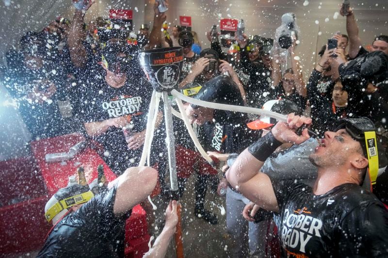 Baltimore Orioles' players drink from the hydration station after clinching a playoff birth by defeating the New York Yankees in baseball game, Tuesday, Sept. 24, 2024, in New York. (AP Photo/Bryan Woolston)