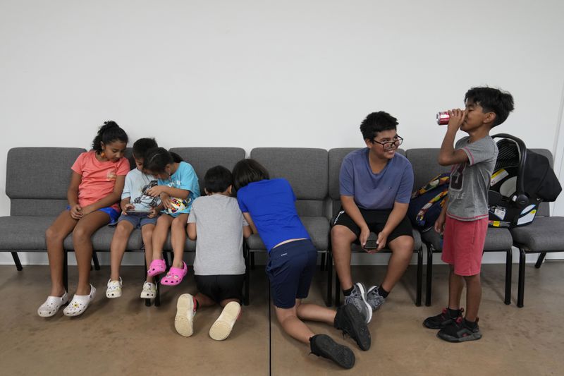 Children talk and play games inside St. Michael the Archangel Catholic church in the aftermath of Hurricane Helene Friday, Oct. 4, 2024, in Erwin, Tenn. (AP Photo/Jeff Roberson)