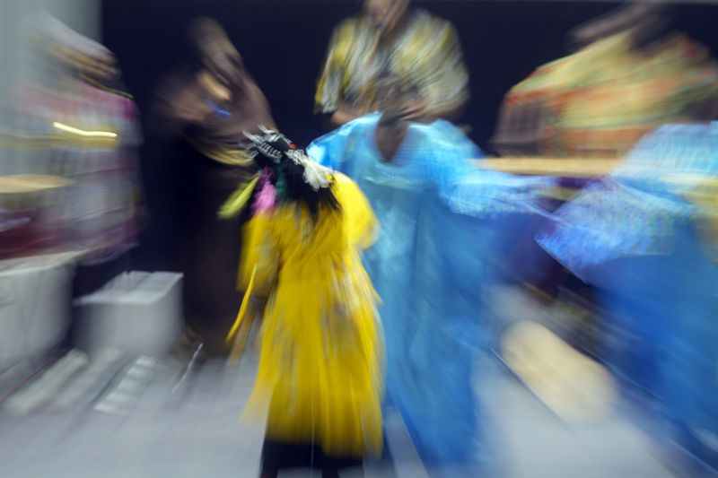 In this image taken with a slow shutter speed, Sudanese Camirata troupe dancers perform a "Al Hamal Rakd" dance from West Sudan, during a show at the Russian culture center in Cairo, Egypt, Sunday, Sept. 15, 2024. (AP Photo/Amr Nabil)