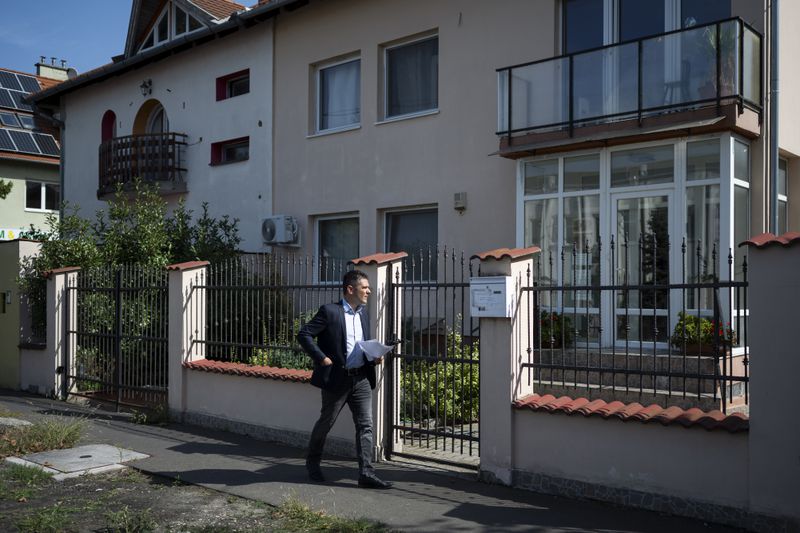 Előd Novak, a member of the National Assembly of Hungary, tries to enter to a house where a Hungarian company that allegedly manufactured pagers that exploded in Lebanon and Syria, is headquartered in Budapest Wednesday, Sept. 18, 2024. (AP Photo/Denes Erdos)