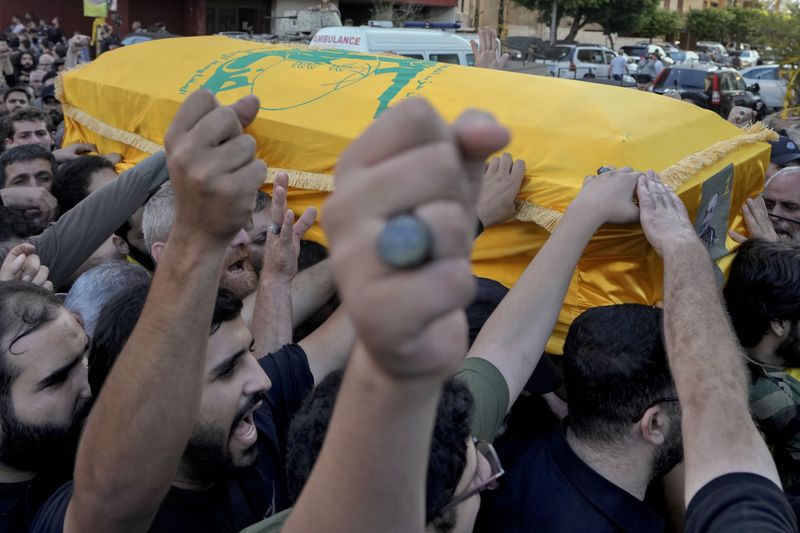 Mourners chant slogans as they carry the coffin of Hezbollah drone commander, Mohammed Hussein Surour, during his funeral procession in Beirut's southern suburbs, Friday, Sept. 27, 2024. (AP Photo/Bilal Hussein)