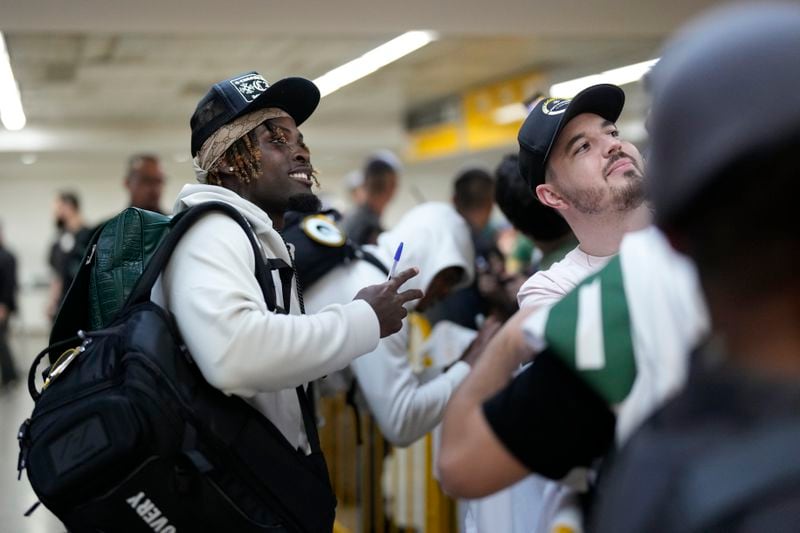 The Green Bay Packers' Jayden Reed poses for a selfie with a fan upon arriving at Sao Paulo International airport ahead of a game against the Philadelphia Eagles, in Guarulhos, greater Sao Paulo, Brazil, Wednesday, Sept. 4, 2024. (AP Photo/Andre Penner)