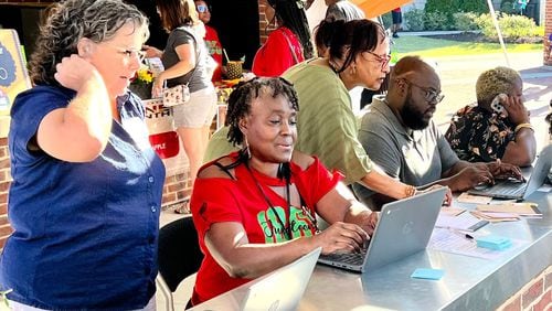 Volunteers work with people in search of their family histories during an event in the Sugar Hill  last year.