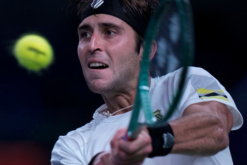 Tomas Martin Etcheverry of Argentina returns a backhand shot to Jannik Sinner of Italy during the men's singles match in the Shanghai Masters tennis tournament at Qizhong Forest Sports City Tennis Center in Shanghai, China, Sunday, Oct. 6, 2024. (AP Photo/Andy Wong)