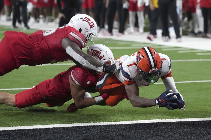 Syracuse running back LeQuint Allen (1) dives in the endzone for a touch down while avoiding UNLV linebacker Jackson Woodard and defensive lineman Alexander Whitmore (95) in overtime of an NCAA college football game, Friday, Oct. 4, 2024, in Las Vegas. (AP Photo/Rick Scuteri)