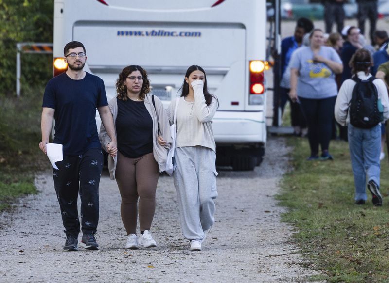 Summer Hishmeh, center, and Sakura Hassan, both from St. Louis, hold hands and cry as they walk with another man away from a protest against the execution of Marcellus Williams outside of the Missouri Department of Corrections prison, Tuesday, Sept. 24, 2024, in Bonne Terre, Mo. (Zachary Linhares/St. Louis Post-Dispatch via AP)