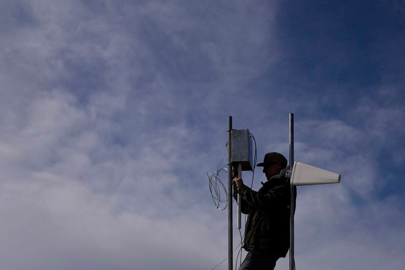 FILE - Carver Cammans installs cloud seeding equipment, Dec. 3, 2022, in Lyons, Colo. (AP Photo/Brittany Peterson, File)