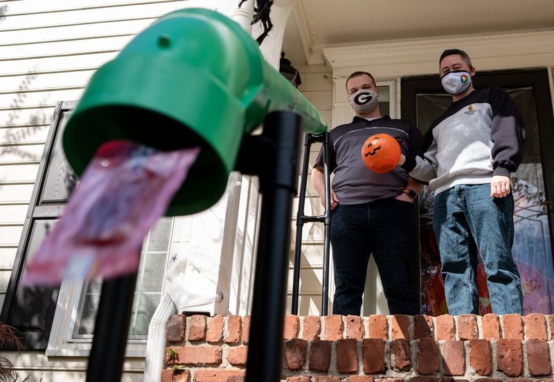 201016-Atlanta-Heath Hall, left, and Ben Ku aren’t sure how many trick-or-treaters they will get this year at their Tucker home, so they built a chute to deliver candy while keeping socially distanced on Halloween. Ben Gray for the Atlanta Journal-Constitution