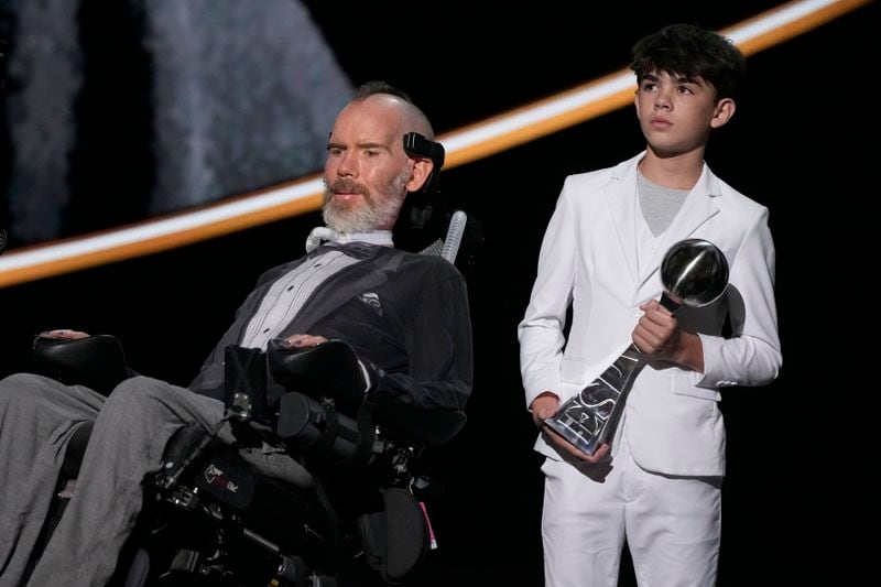 Steve Gleason, left, recieves the Arthur Ashe Award for Courage, held by his son Rivers, right, at the ESPY awards on Thursday, July 11, 2024, at the Dolby Theatre in Los Angeles. (AP Photo/Mark J. Terrill)