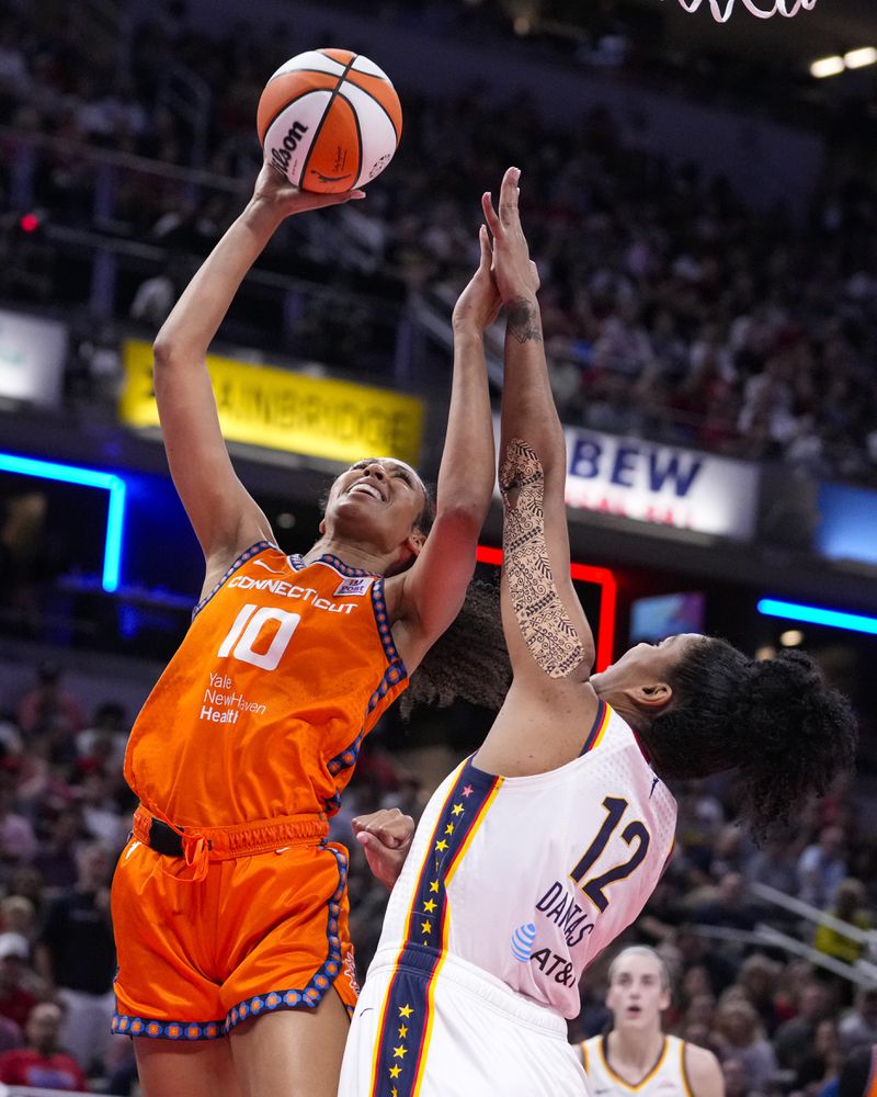 Connecticut Sun forward Olivia Nelson-Ododa (10) shoots over Indiana Fever forward Damiris Dantas (12) in the first half of a WNBA basketball game in Indianapolis, Wednesday, Aug. 28, 2024. (AP Photo/Michael Conroy)