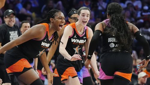 Arike Ogunbowale, right, of Team WNBA, celebrates after her 3-point basket against Team USA with teammates Caitlin Clark, center, and Aliyah Boston, left, during the second half of a WNBA All-Star basketball game Saturday, July 20, 2024, in Phoenix. (AP Photo/Ross D. Franklin)