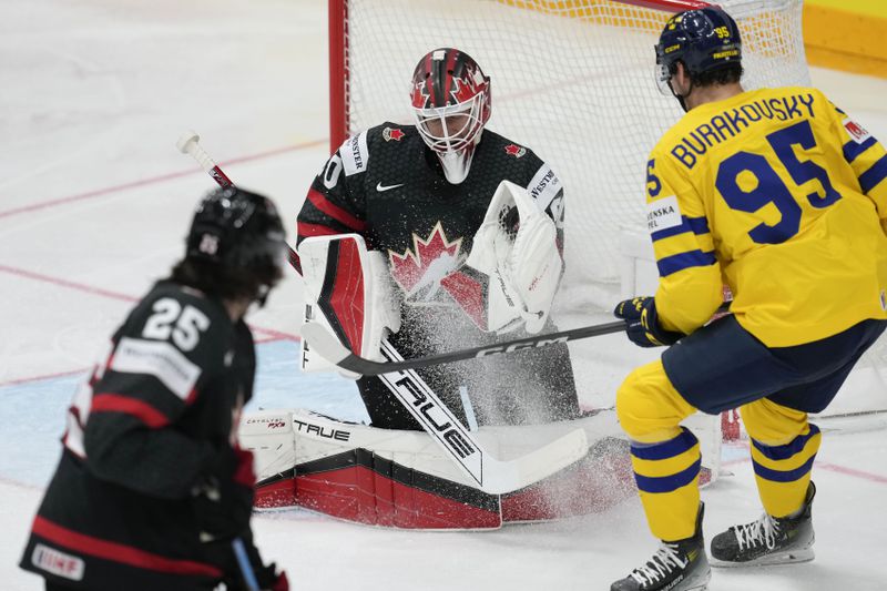 Canada's goalkeeper Jordan Binnington, center, makes a save in front of Sweden's Andre Burakovsky, right, during the bronze medal match between Sweden and Canada at the Ice Hockey World Championships in Prague, Czech Republic, Sunday, May 26, 2024. (AP Photo/Darko Vojinovic)