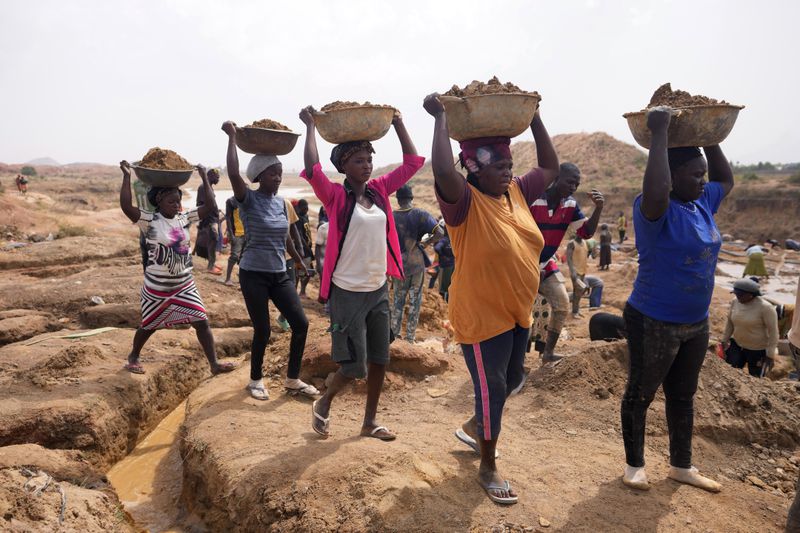 Women work at an Illegal tin mining site in Jos, Nigeria, Wednesday, April 3, 2024. The recent arrests come as Nigeria seeks to regulate mining of critical minerals, curb illegal activity and better benefit from its mineral resources. (AP Photo/Sunday Alamba)