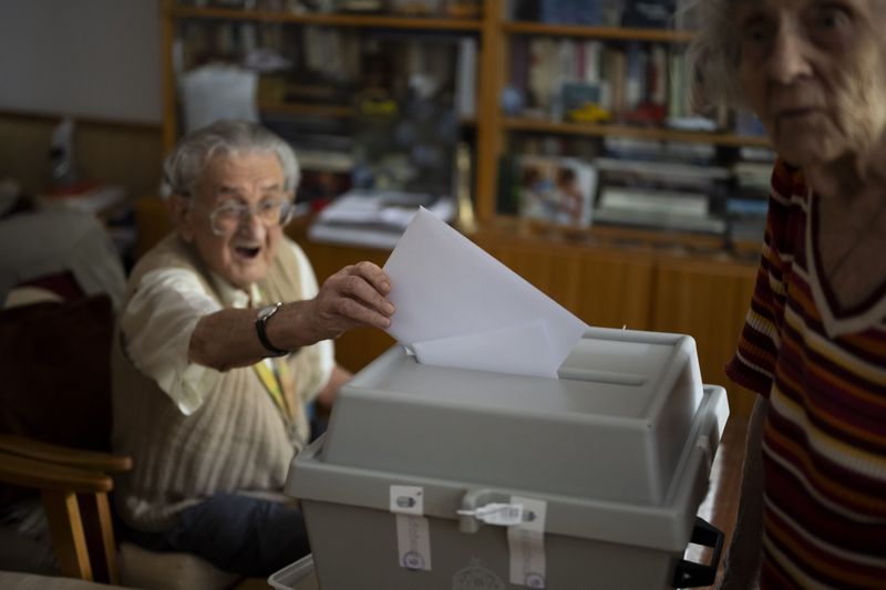 An elderly man casts his ballot in a mobile ballot box during European Parliamentary elections, in Budapest, Hungary, Sunday, June 9, 2024. (AP Photo/Denes Erdos)