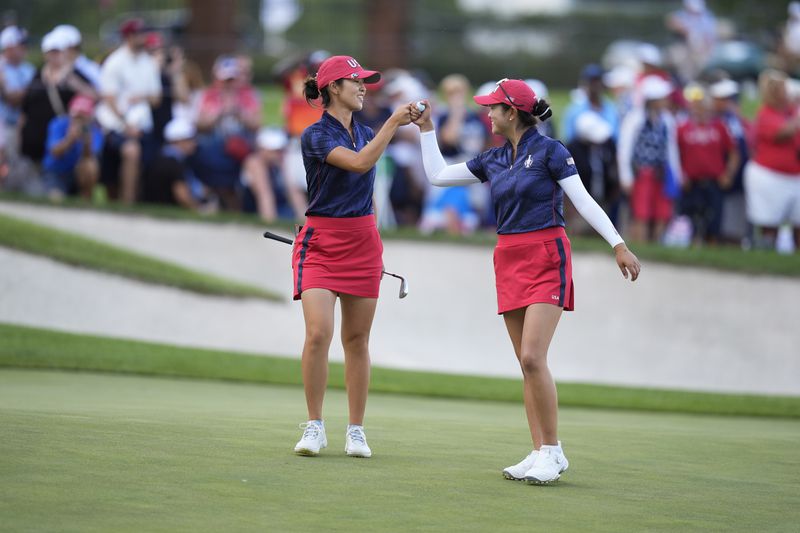 United States' Andrea Lee, left, and teammate Rose Zhang celebrate after winning a fourball match during a Solheim Cup golf tournament at Robert Trent Jones Golf Club, Friday, Sept. 13, 2024, in Gainesville, Va. (AP Photo/Chris Szagola)